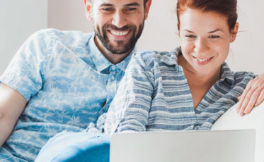 Couple looking at first home on a laptop