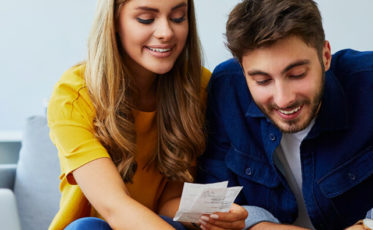 Couple on couch looking at shopping receipts