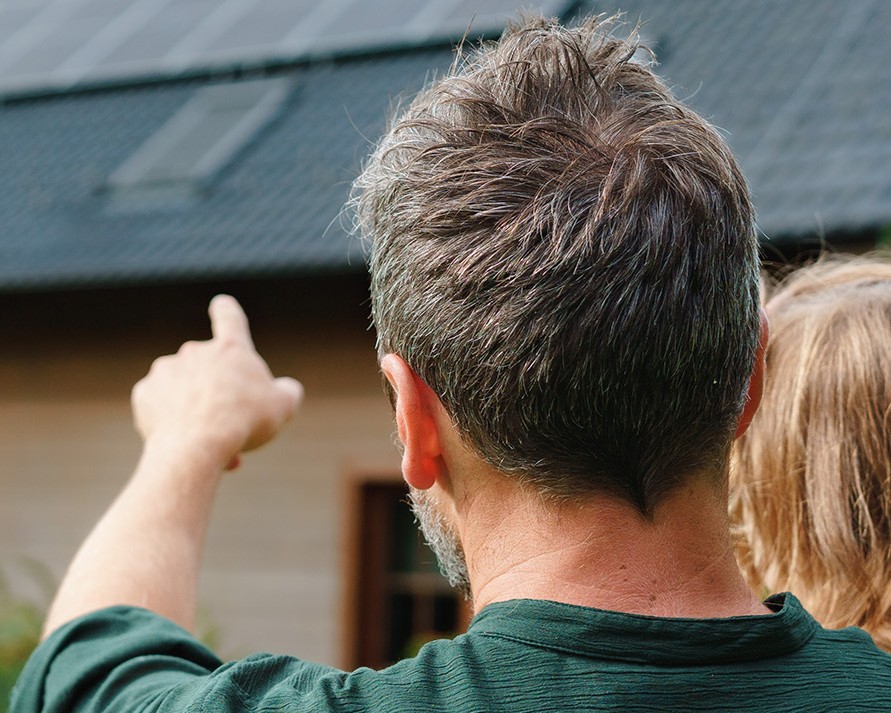 A man and a child pointing at house.