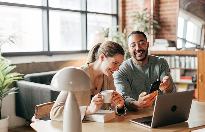 Couple sitting down and using on a laptop
