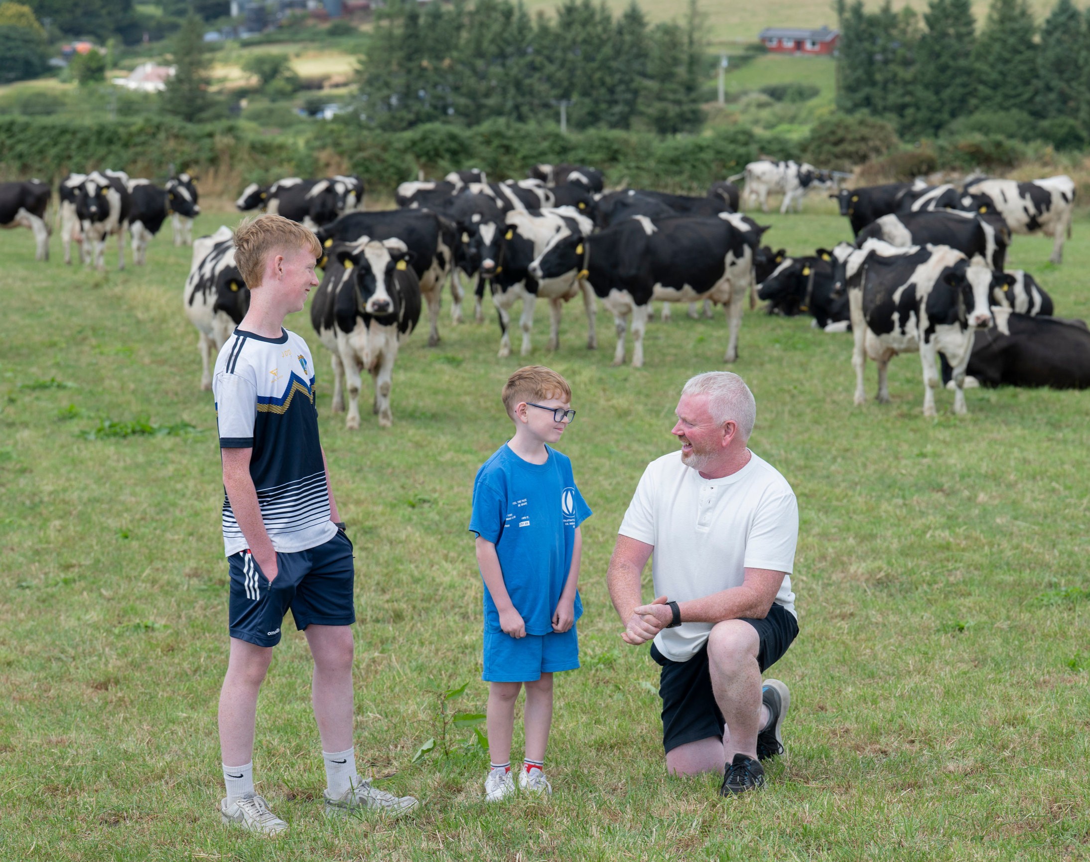 A father and his two young sons on a farm.