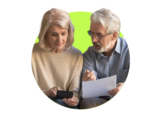 An older couple holding paper and a calculator.
