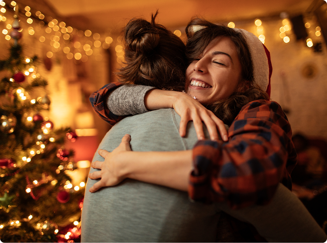 Photograph of two women hugging at Christmas time.