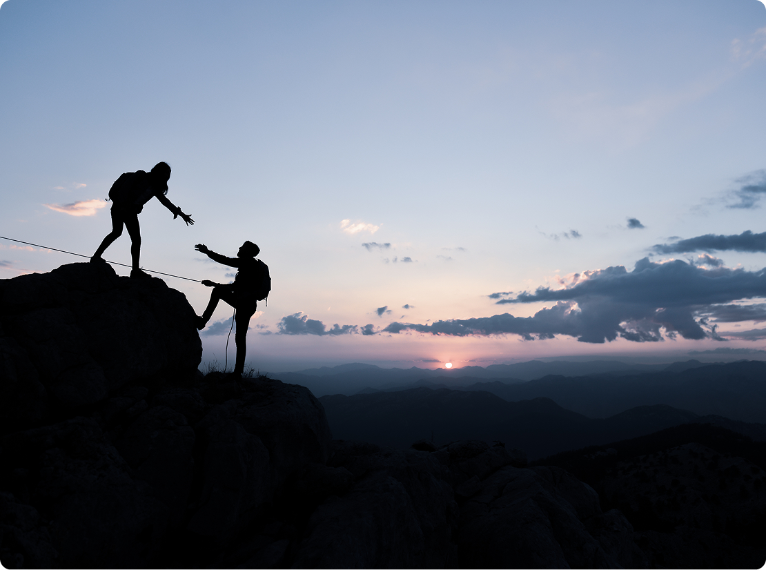 Two people climbing a mountain.