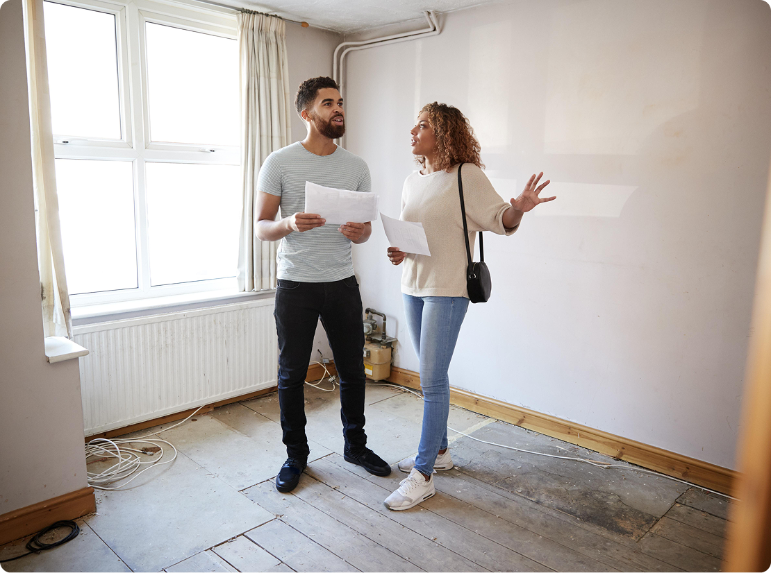 A couple discussing the empty room that the are in.