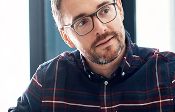 A male mobile mortgage manager customer with a beard and glasses wearing a blue and red tartan shirt